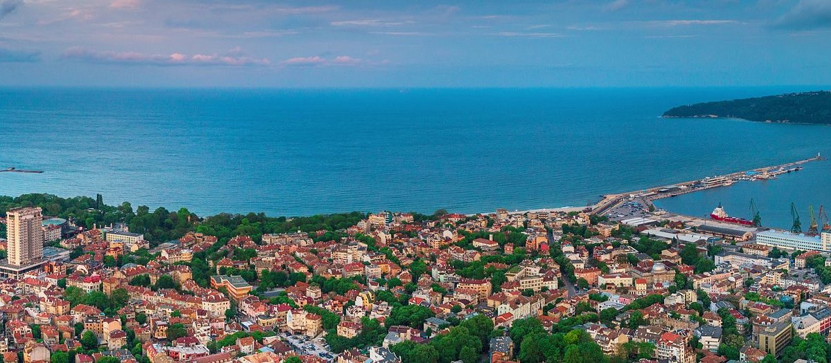 Aerial view of Varna city along the Black Sea coastline with rooftops streets and the sea horizon conveying a calm expansive atmosphere